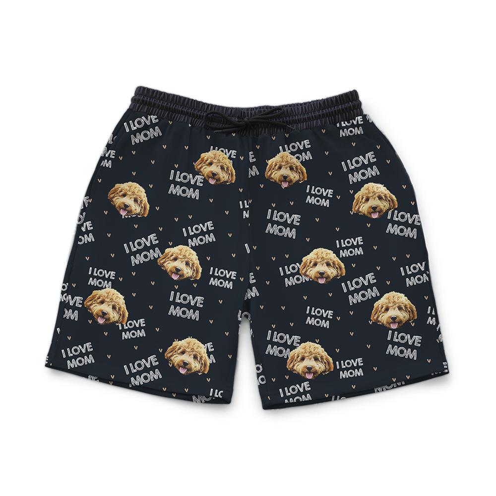 Black sweat shorts patterned with repeated “I LOVE MOM” text, small tan hearts, and multiple images of a fluffy light-brown dog’s face.