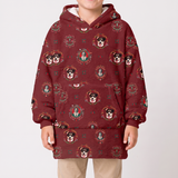 A child wearing a burgundy hooded sweatshirt with an all-over print of French Bulldog portraits in ornate circular frames, paired with beige pants, against a plain light gray studio background.