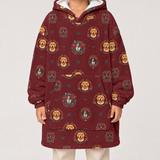 A person wearing a burgundy hooded sweatshirt with a repeating print of golden retriever dogs in ornate circular frames, paired with light beige pants, against a plain light gray studio background.