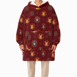 A person wearing a burgundy hooded sweatshirt with an all-over repeating print of orange cats in decorative frames, paired with light beige pants, against a plain white background.