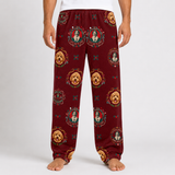 A person wearing burgundy fleece pants with an all-over print of Mexican folk art portraits of Frida Kahlo and golden dogs, shown from the waist down on a light gray studio background.