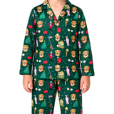 A person wearing a matching long-sleeve pajama set with a dark green background and an all-over festive print featuring golden retriever dog faces, Santa Claus, Christmas trees, houses, and small red and pink accents, photographed against a plain white studio background.