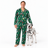 A man wearing a green long-sleeve pajama set with a Christmas-themed dog and golf pattern stands barefoot next to a Dalmatian dog on a white studio background.