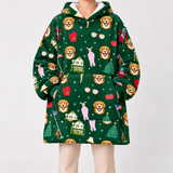 A person wearing a dark green hooded sweatshirt with an all-over festive print featuring golden retriever faces, red envelopes, small houses, Christmas trees, and holiday icons. The photo is cropped from the neck down against a plain light gray studio background.
