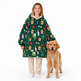 A young girl wearing a green Christmas-themed hooded sweatshirt with a lion and house pattern, standing next to a golden retriever dog on a white background.