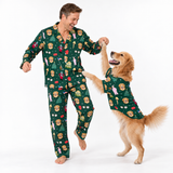 A man and his golden retriever dog are both wearing matching green pajamas with a festive dog-themed print, dancing and play-fighting on a white studio background.
