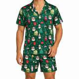 A man modeling a matching green short-sleeve button-up shirt and shorts pajama set with a festive Christmas dog print, shown against a plain white background.
