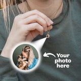 Person wearing a gold photo-projection necklace with an inset image of a woman and cat.