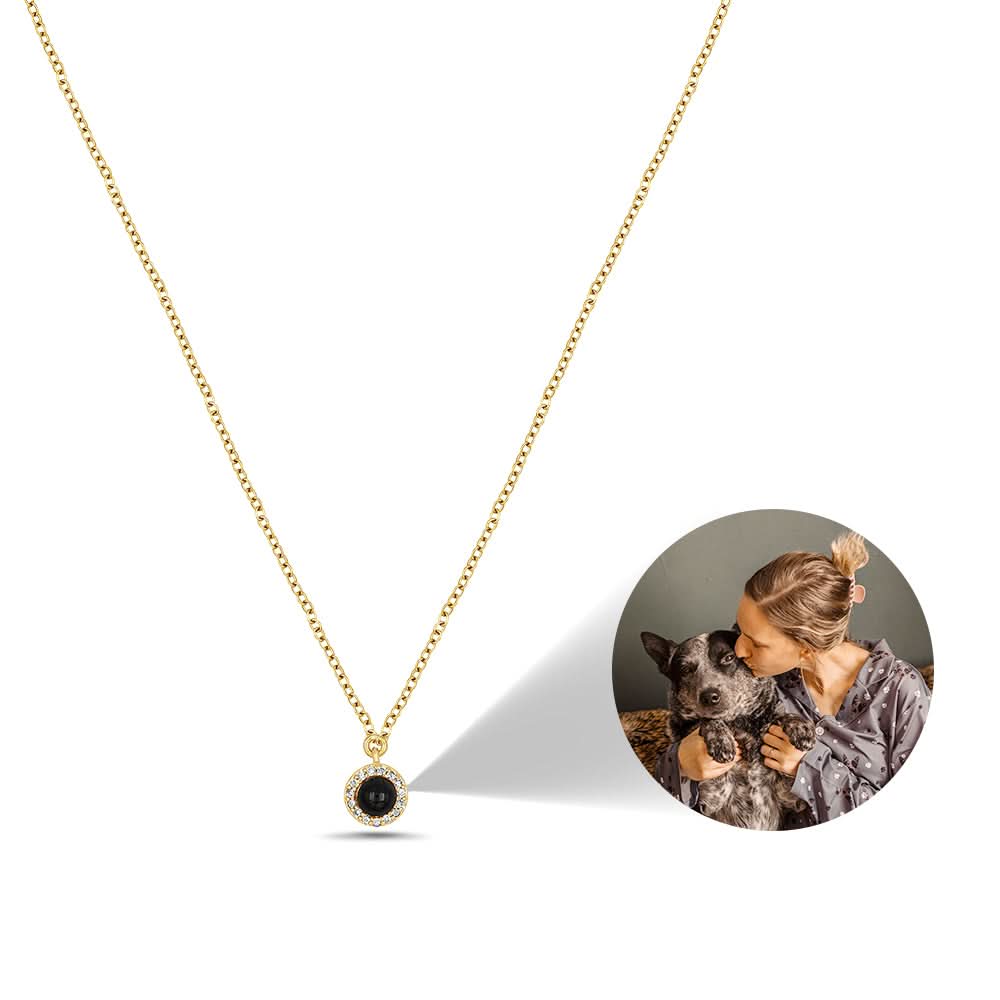 Gold pet-photo necklace on white background with an inset of a person holding a dog.