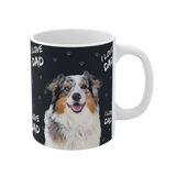 Black ceramic mug with paws and the phrase "I Love Dad", featuring a smiling, multicolored Australian Shepherd