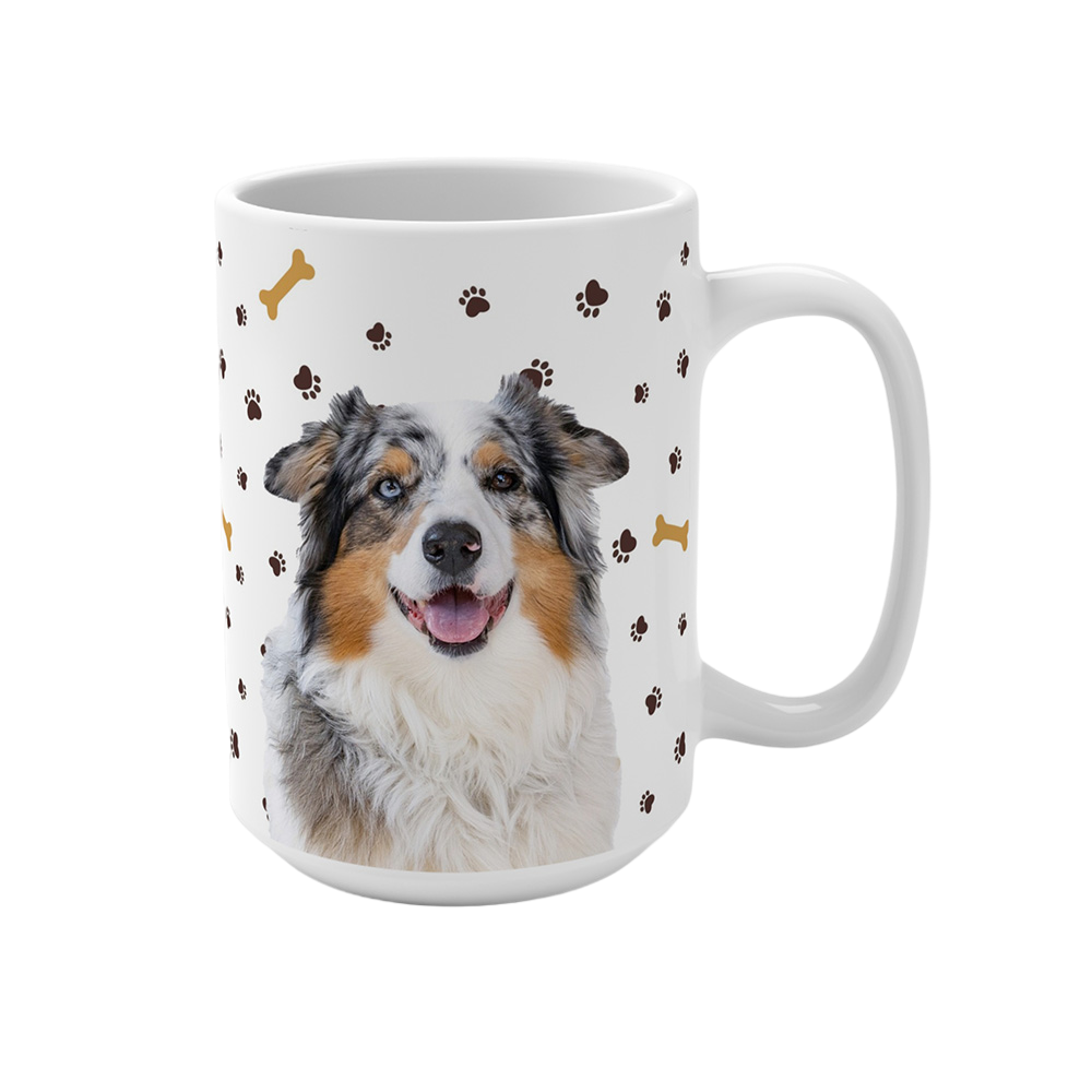 White ceramic mug with paws and bones pattern, featuring a smiling, multicolored Australian Shepherd