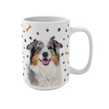 White ceramic mug with paws and bones pattern, featuring a smiling, multicolored Australian Shepherd