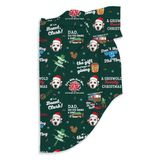 A folded dark green fabric item, likely a blanket or towel, printed with a festive Christmas-themed graphic pattern featuring a Grizwold dog, text, and holiday motifs on a white background.
