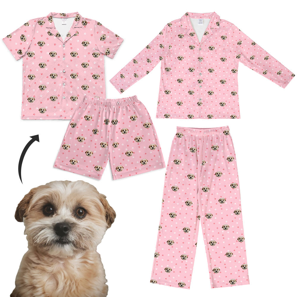 Custom pink pajama sets featuring an all-over print of a small fluffy dog’s face and white paw prints, shown in both short-sleeve/shorts and long-sleeve/pants options beside the original dog photo used for the design.