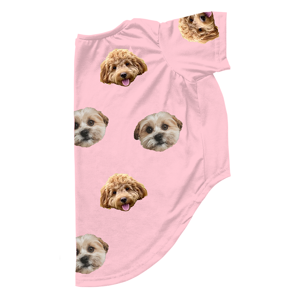 Light pink dog pajama outfit featuring a repeating pattern of two different small dog faces printed across the fabric.
