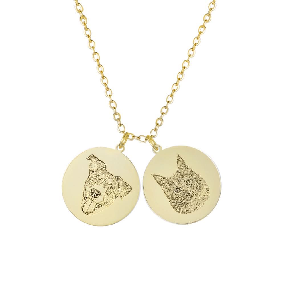 Two gold circular pendants on a necklace chain, each engraved with the portrait of a pet.