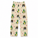 A pair of beige fleece pants with an all-over Christmas elf print, featuring green and yellow elf figures, black-and-white cat faces, candy canes, and red paw prints.
