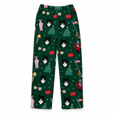 A pair of dark green children's pajama pants featuring a festive Christmas print with black and white cat faces, Christmas trees, candy canes, Santa Claus figures, and American flags, shown flat against a white background.