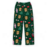 A pair of dark green children's pants featuring a festive Christmas print with golden retriever dog faces, Christmas trees, Santa Claus, and holiday icons, shown flat against a white background.