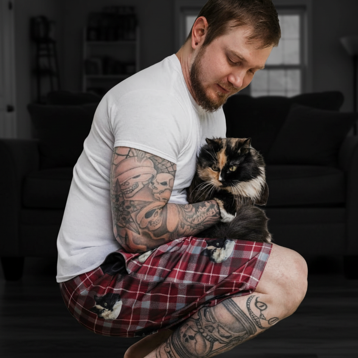 Man with sweatshorts holding a cat in a living room setting