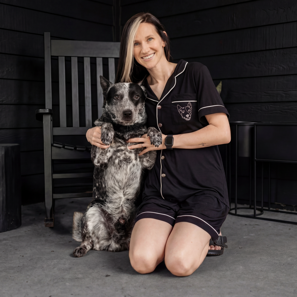 Woman wearing a black bamboo pajama with a dog