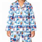 A person wearing a matching long-sleeve pajama top and pants set with a blue and white cartoon dog-and-snowman print, shown against a plain white background.