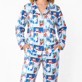 A woman wearing a matching long-sleeve pajama set with a blue and white cartoon dog print, standing against a plain white background.
