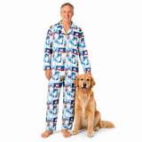 A man wearing a long-sleeve pajama set with a colorful cartoon dog print stands barefoot next to a golden retriever dog on a plain white background.