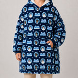 A child wearing a navy blue hooded sweatshirt with a white sherpa lining and an all-over 'Freshly Squeezed' dog print, paired with beige pants, against a neutral studio background.