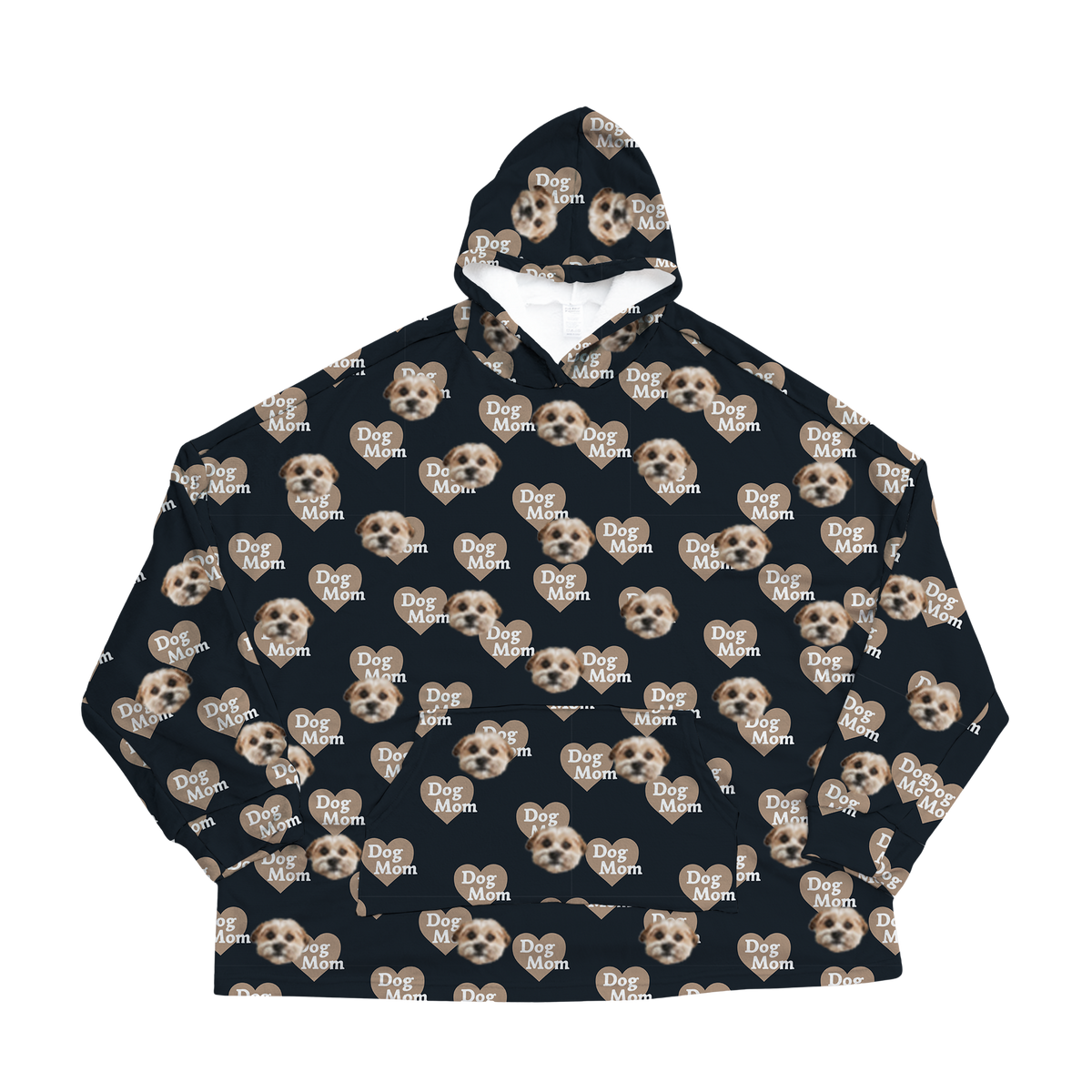 A black oversized blanket hoodie with a repeating custom pattern. The pattern features several close-up photos of a small, light-colored dog's face, interspersed with graphics of tan hearts that contain the white text "Dog Mom".