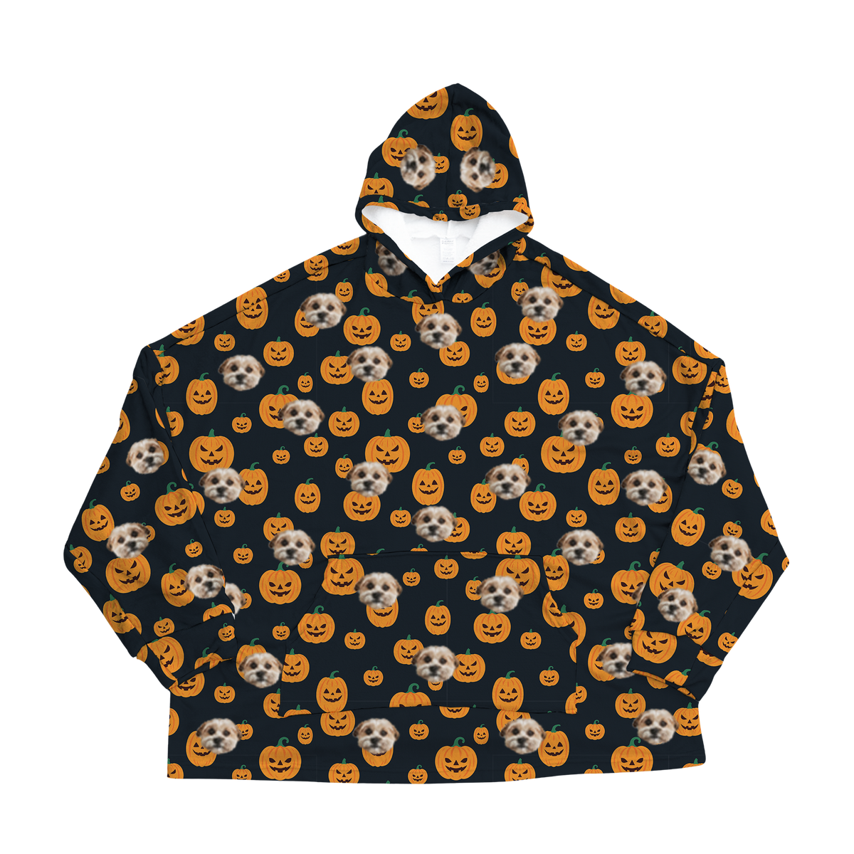 A black oversized blanket hoodie with a repeating custom pattern. The pattern features several close-up photos of a small, light-colored dog's face, interspersed with graphics of orange pumpkins and jack-o'-lanterns with various carved faces.