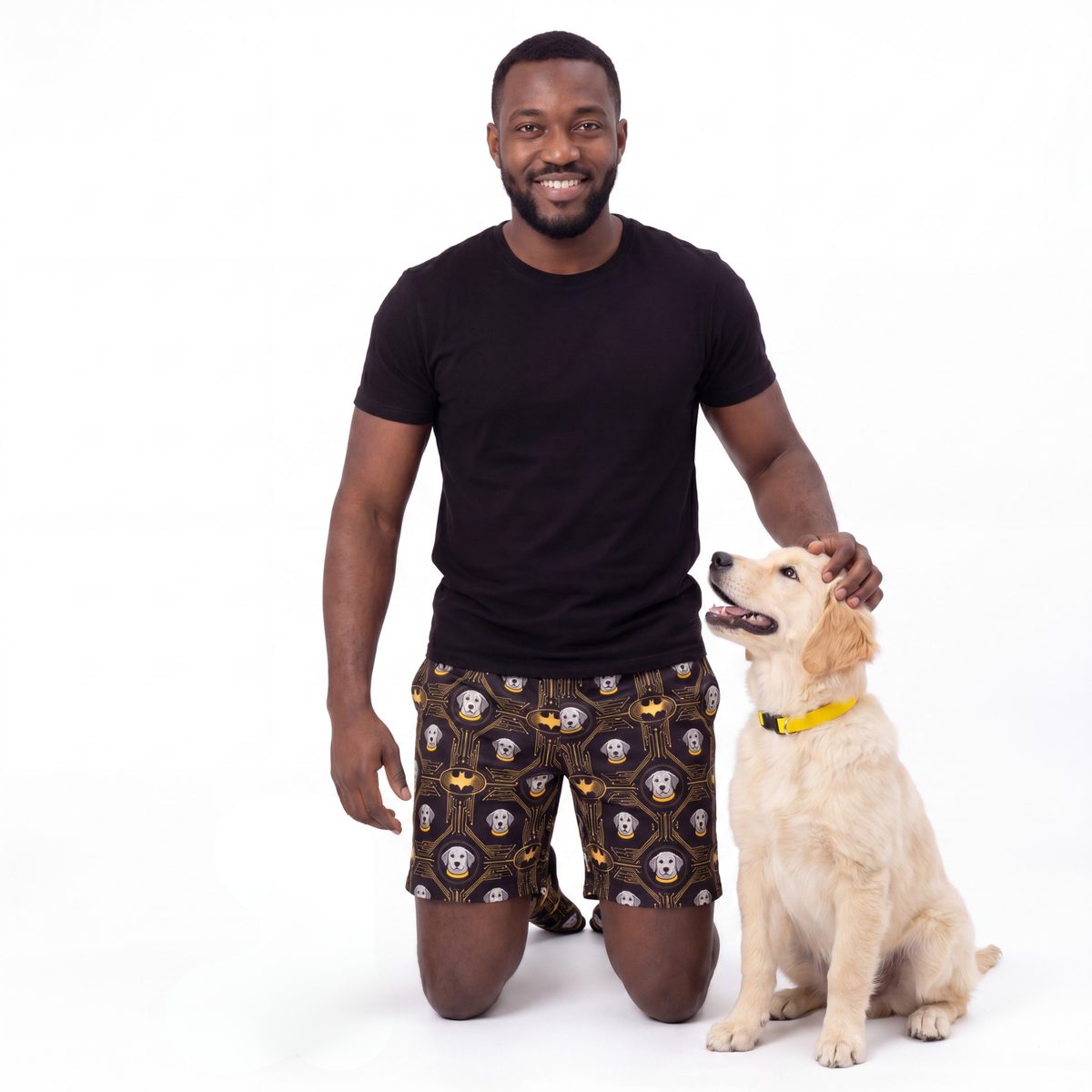 Man wearing batman shorts with a dog on a white background