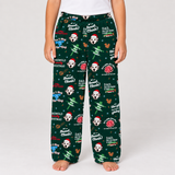 A person wearing dark green Christmas-themed pajama pants with a Dalmatian dog and 'Dad' print, standing against a light gray studio background.