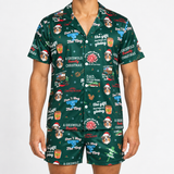 A man wearing a matching short-sleeve button-up pajama shirt and shorts set in dark green with a festive Christmas dog print. The print features cartoon dogs in Santa hats, the text 'Don't Trog the Nog', 'A Griswold Christmas', and holiday-themed illustrations, shown against a plain white background.