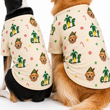 Two dogs wearing matching cream-colored pet shirts with a festive Elf on the Shelf pattern, shown from behind against a white background.