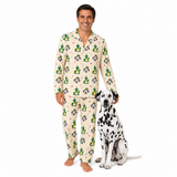 A man wearing a two-piece pajama set with a cactus and dog print stands next to a Dalmatian dog on a solid white background.