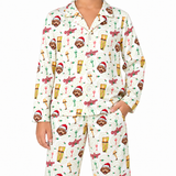 A person wearing a matching long-sleeve pajama set with an all-over Christmas-themed print featuring teddy bears in Santa hats, ornaments, and the word 'Ozzy' on a white background.