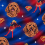 Close-up of the Iconic Supergirl print showing custom pet faces with Supergirl figures and shields on a blue and red fabric