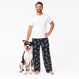 Man wearing a white t-shirt and black pajama pants with a dog on a white background