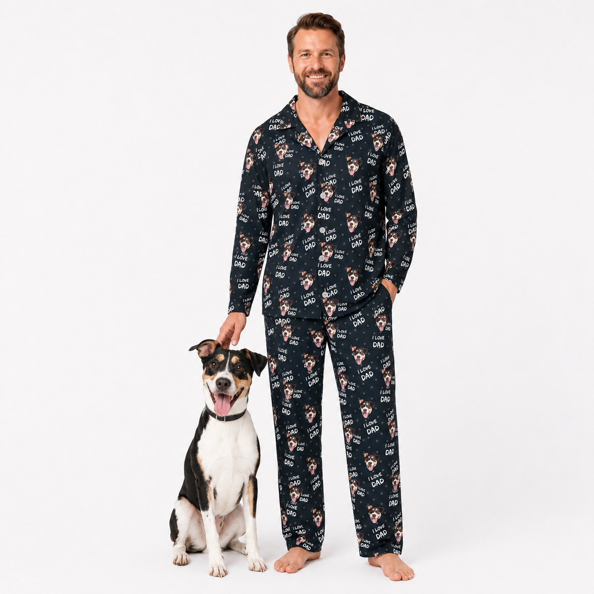 Man wearing a black pajama set with dog print standing next to a dog on a white background