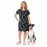 Woman wearing a black nightgown with 'I love Dad' print, standing next to a dog on a white background