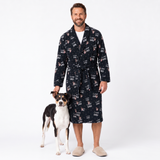 A man wearing a black 'I Love Dad' print robe stands next to a black and white dog on a white studio background.