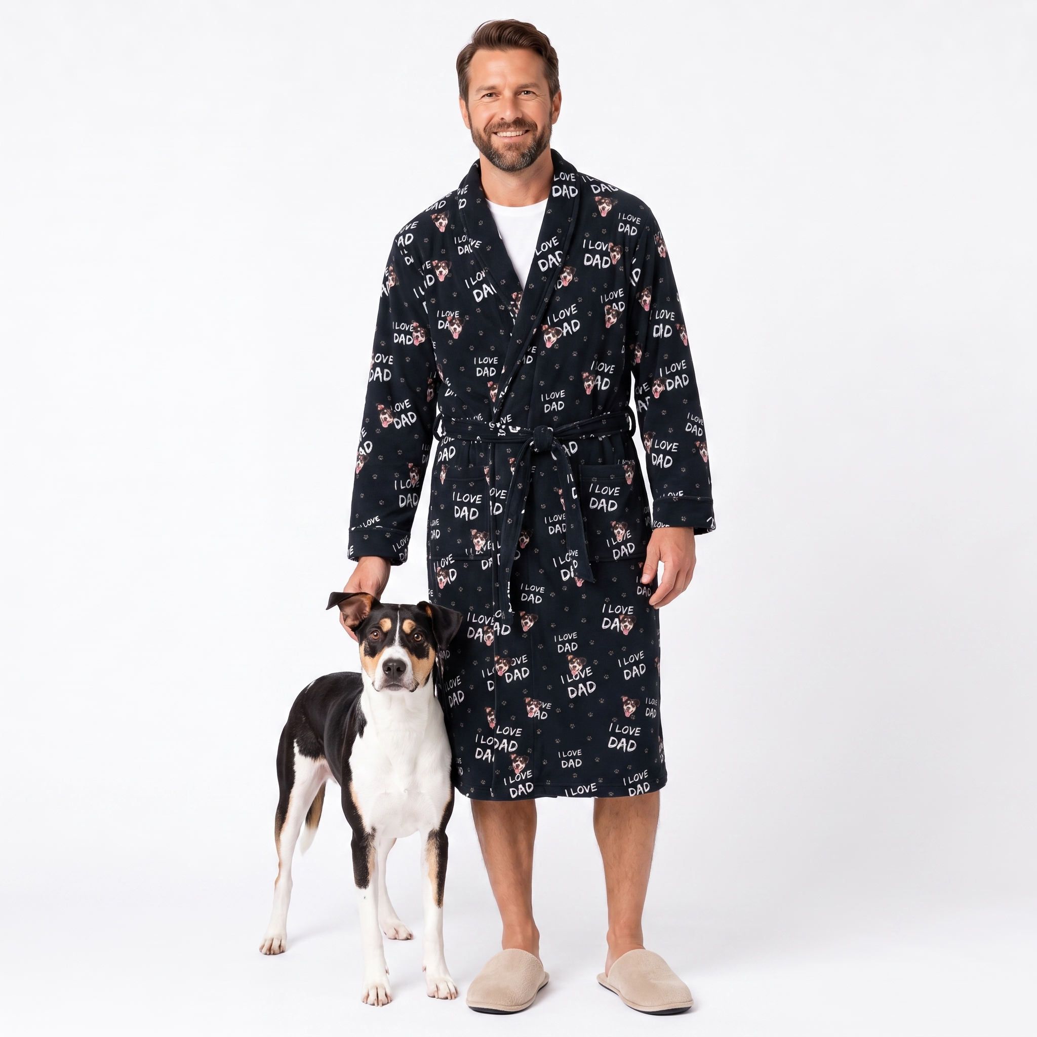 A man wearing a black 'I Love Dad' print robe stands next to a black and white dog on a white studio background.