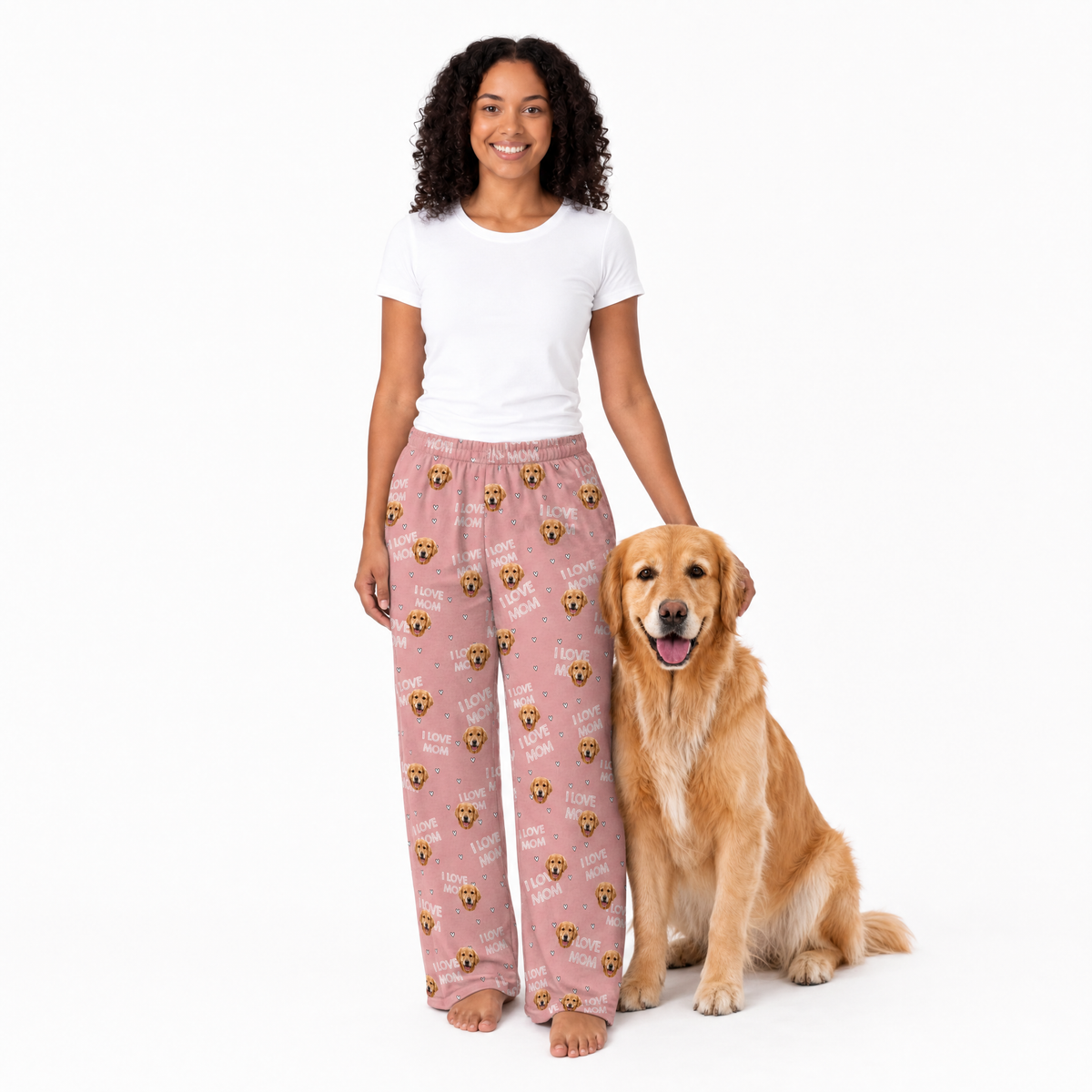 Woman wearing pink pajama pants with a dog sitting next to her on a white background