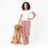 Woman wearing pink pajama pants with a dog on a white background