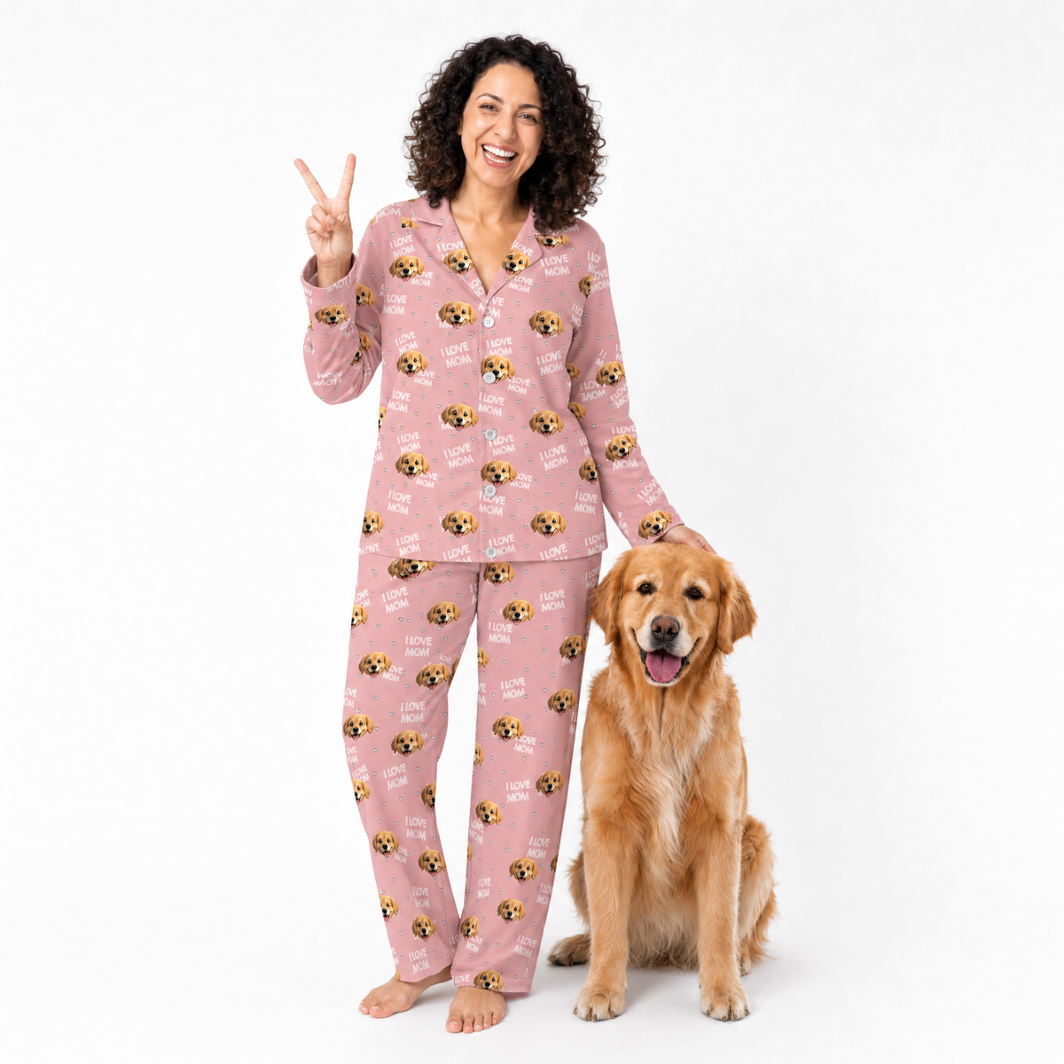 Woman in pink pajamas with dog pattern and a golden retriever on a white background