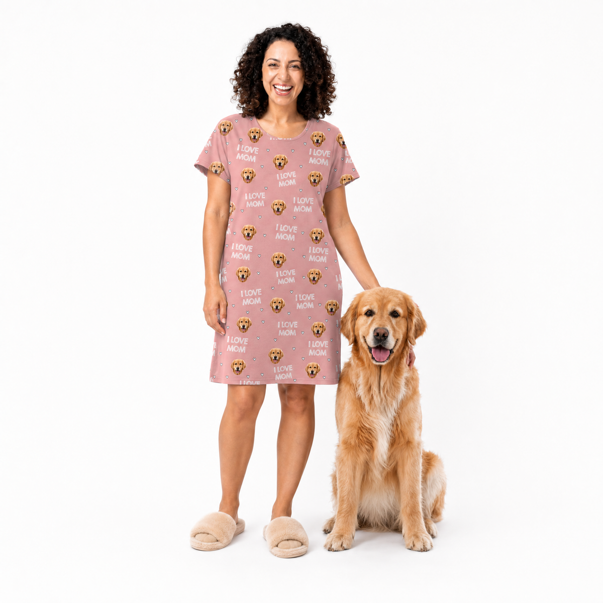 Woman wearing a pink nightgown with dog-themed print standing next to a golden retriever on a white background