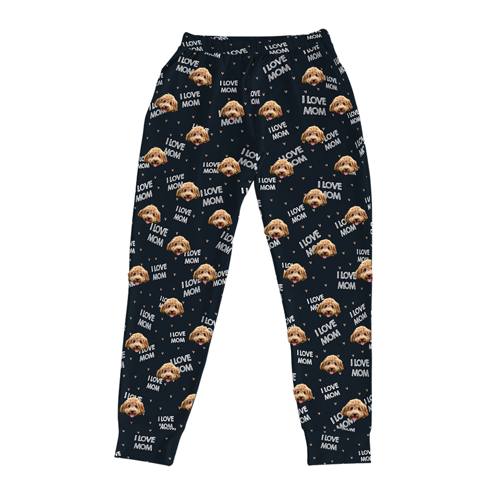 A pair of black jogger pajama bottoms. They feature a repeating custom pattern of a light brown Goldendoodle's face, interspersed with the white text "I LOVE MOM" and small heart shapes.