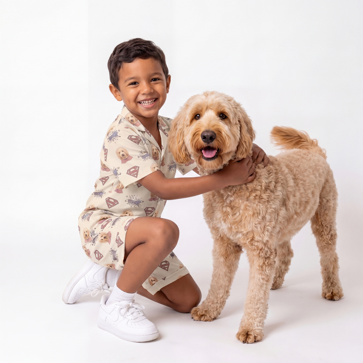 Child wearing a superman pajama set with a dog on a white background