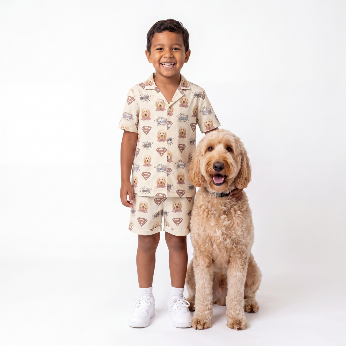 Child wearing a superman pajama set with a dog on a white background
